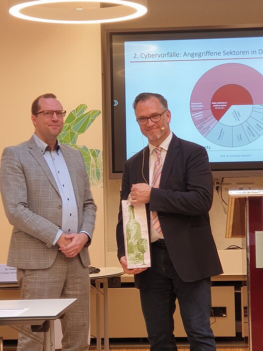 Übergabe einer Flasche Wein als Gastgeschenk von Larsen an Prof. Dr. Harnisch