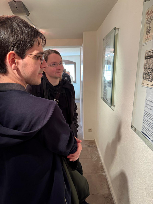 zwei Personen schauen sich ein Exponat im Keplermuseum an