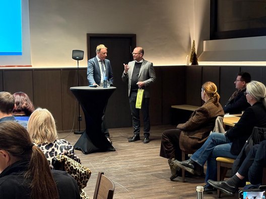 Dr. Larsen bedankt sich bei Jörg Krauss mit einem Präsent für den Vortrag 