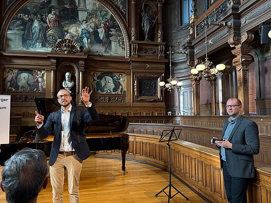 Joost Punstein spricht vor Besucherinnen und Besuchern in der historischen Alten Aula der Universität Heidelberg.